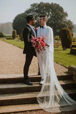 Groom in Black Suit & Fedora Hat With Groom in White Suit With Cape Veil