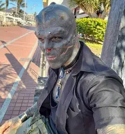 A MAN has transformed himself into a 'black alien'