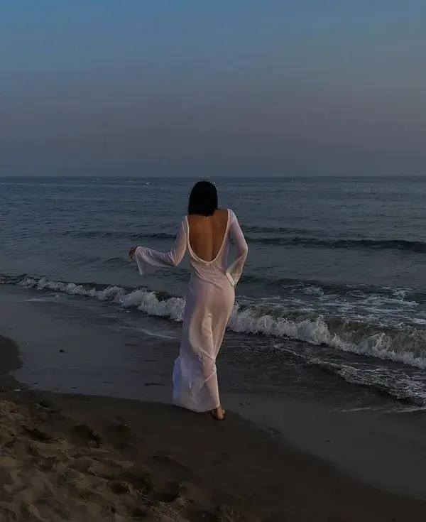 Wet girl in white dress at the beach