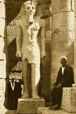 Colossal statue of Ramesses II among columns of the Temple of Luxor, c.1908.