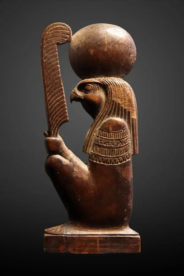 God Ra-Horakhty ('Ra, who is Horus of the Two Horizons') holding the feather of the goddess Maat.